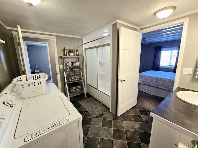 133 Lake Shore Dr, Craig, MO 64436 - washroom featuring a sink, a textured ceiling, laundry area, independent washer and dryer, and dark tile patterned floors