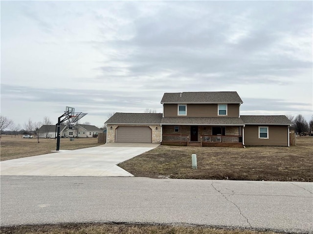 traditional home with a garage, driveway, a porch, and a shingled roof