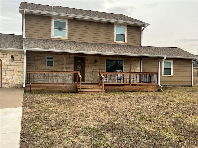 view of front of home featuring stone siding, a porch, a front lawn, and a shingled roof