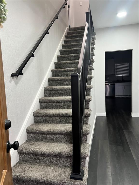 stairway featuring recessed lighting, baseboards, and wood finished floors