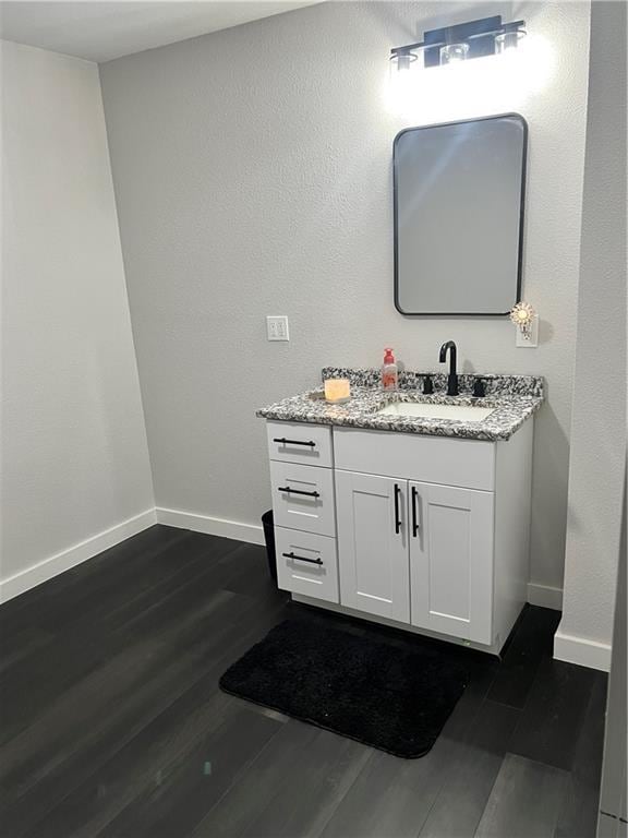 bathroom featuring wood finished floors, vanity, and baseboards