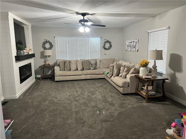 living room with a large fireplace, baseboards, a ceiling fan, and carpet flooring