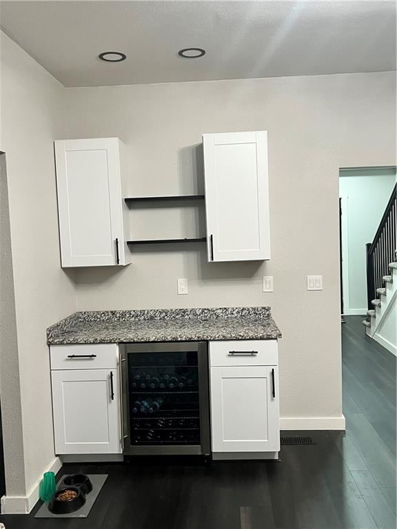 kitchen with beverage cooler, white cabinetry, open shelves, and baseboards