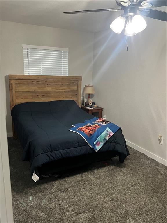 carpeted bedroom featuring ceiling fan and baseboards