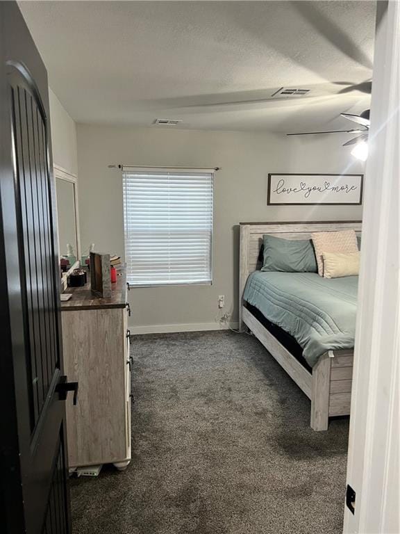 bedroom featuring visible vents, dark carpet, and baseboards