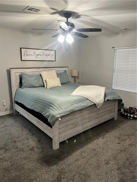 carpeted bedroom featuring ceiling fan and visible vents