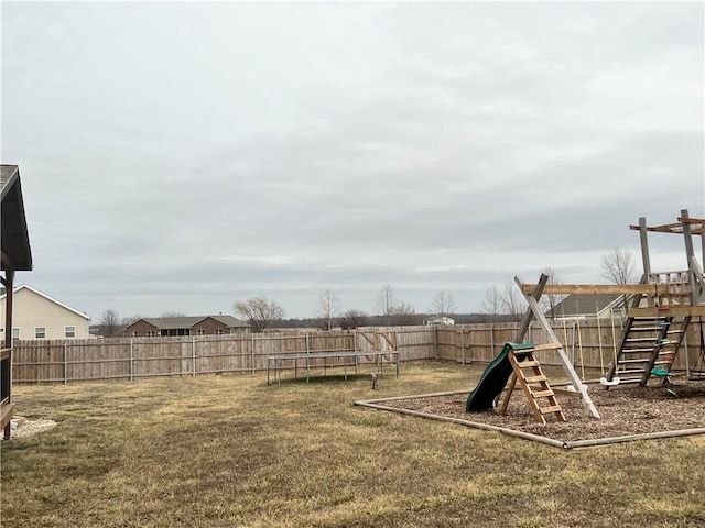 view of jungle gym featuring a trampoline, a fenced backyard, and a lawn