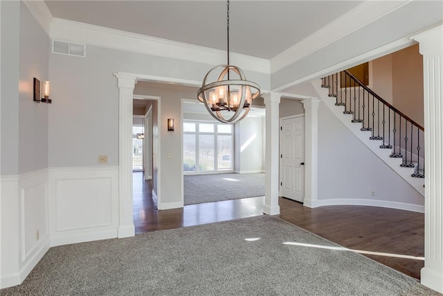 interior space featuring visible vents, a notable chandelier, dark colored carpet, stairs, and ornate columns