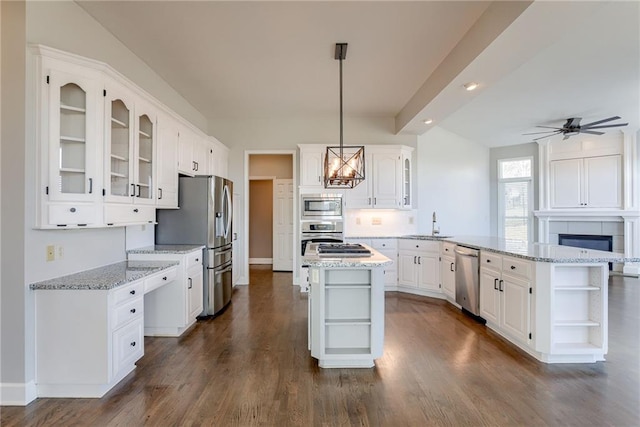 kitchen featuring open shelves, stainless steel appliances, a peninsula, white cabinets, and glass insert cabinets