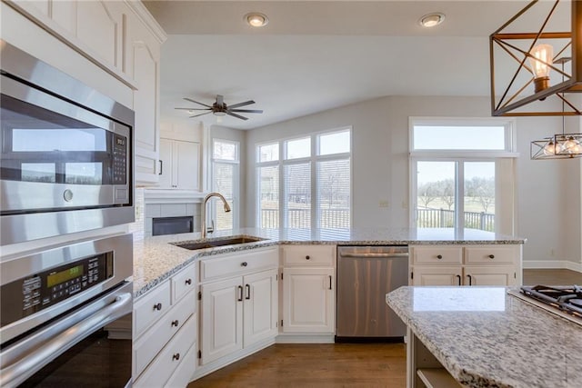 kitchen featuring white cabinets, stainless steel appliances, dark wood-type flooring, and a sink