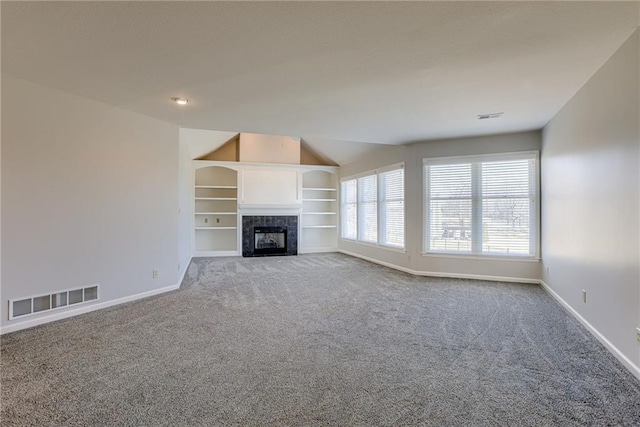 unfurnished living room with carpet flooring, baseboards, visible vents, and a tile fireplace