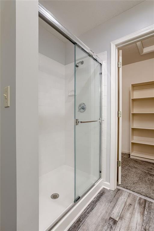 full bathroom with a stall shower and wood finished floors