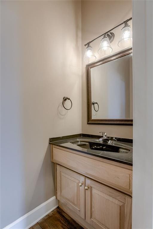 bathroom featuring vanity, baseboards, and wood finished floors