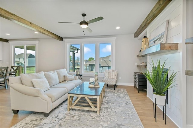 living area featuring beamed ceiling, light wood-type flooring, a wealth of natural light, and recessed lighting