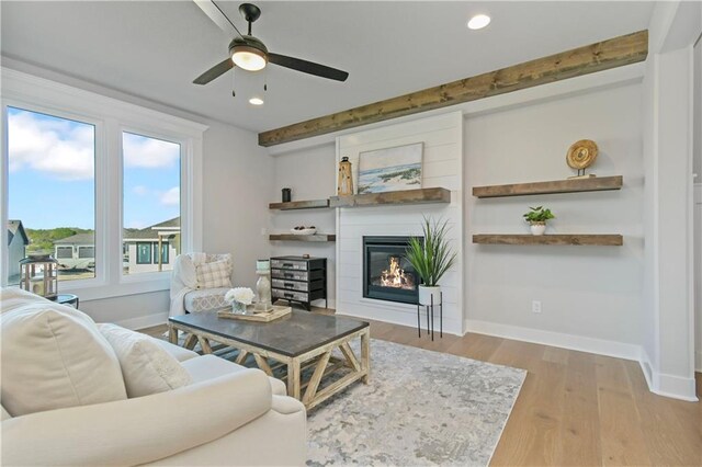 living room with recessed lighting, baseboards, wood finished floors, and a glass covered fireplace