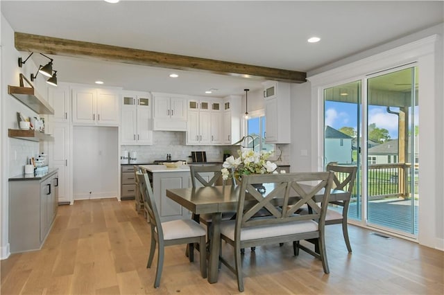 dining space featuring visible vents, light wood-type flooring, beam ceiling, and recessed lighting