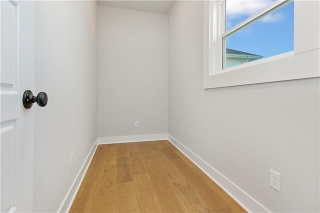 empty room featuring light wood finished floors and baseboards