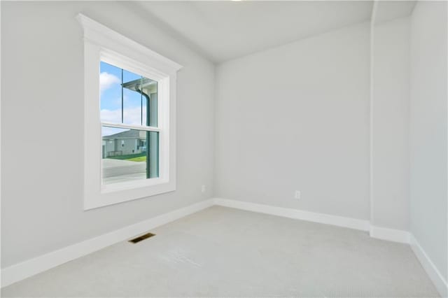 carpeted spare room featuring visible vents and baseboards