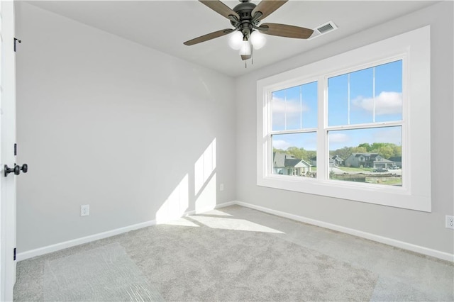 spare room with carpet floors, visible vents, and baseboards