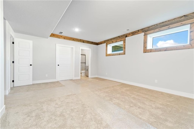 empty room featuring light carpet, recessed lighting, visible vents, and baseboards