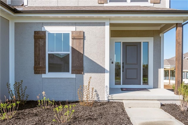 doorway to property featuring stucco siding