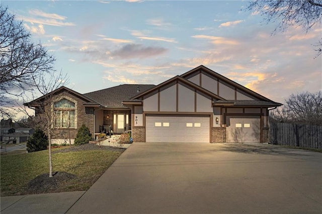 view of front of house with brick siding, driveway, a garage, and fence