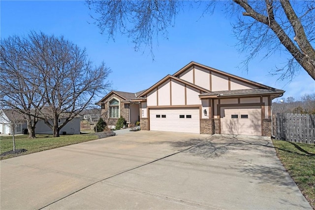 english style home featuring a front lawn, fence, concrete driveway, stucco siding, and an attached garage