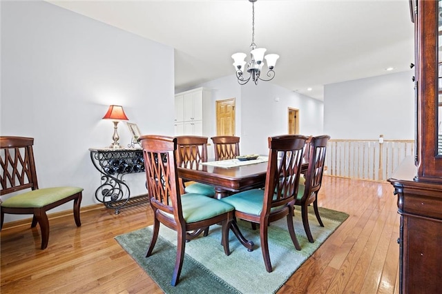 dining area with recessed lighting, light wood-type flooring, and an inviting chandelier