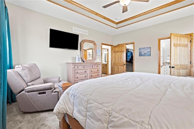 bedroom with visible vents, ensuite bathroom, carpet, a raised ceiling, and a spacious closet