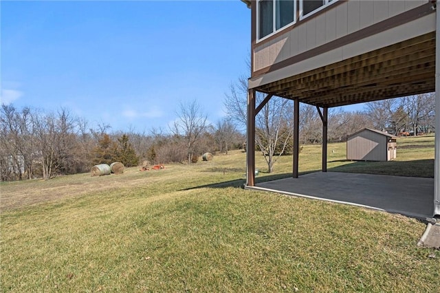 view of yard with a storage shed, an outdoor structure, and a patio area