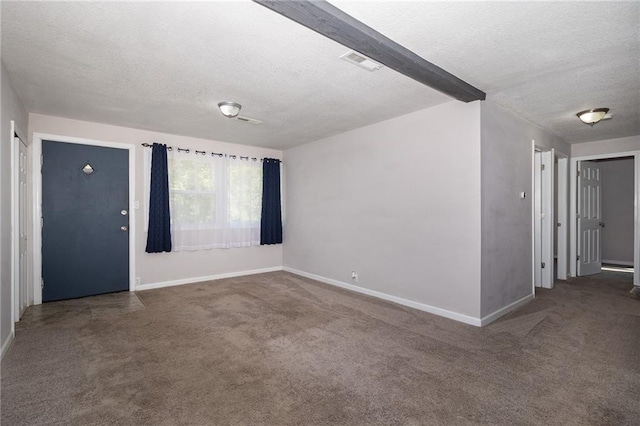 empty room featuring baseboards, carpet, visible vents, and a textured ceiling