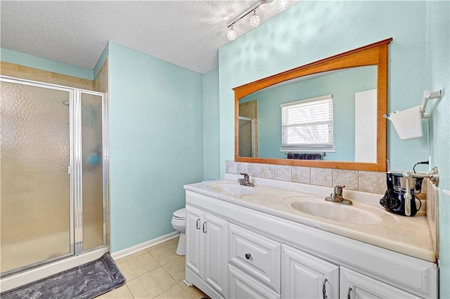 bathroom featuring a stall shower, tile patterned flooring, and a sink