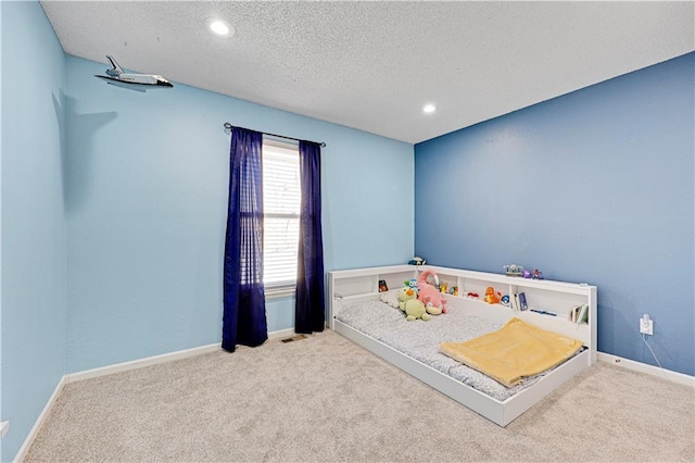 carpeted bedroom with visible vents, baseboards, a textured ceiling, and recessed lighting