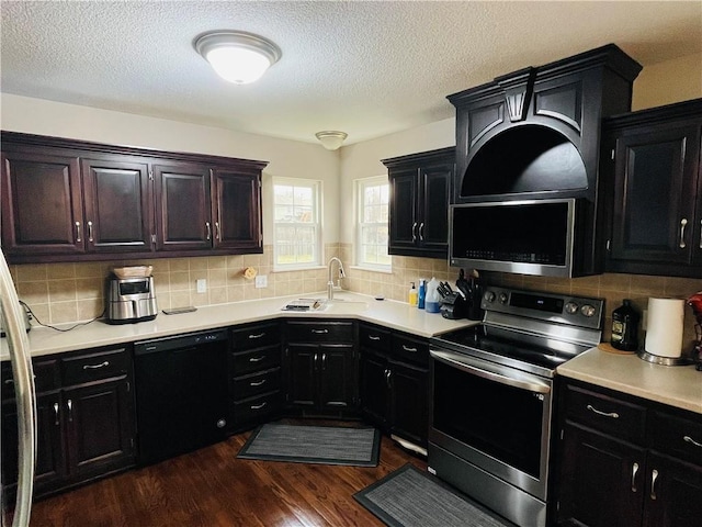 kitchen with dishwasher, stainless steel electric range oven, dark wood-type flooring, and light countertops