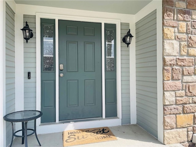 property entrance featuring stone siding and a porch