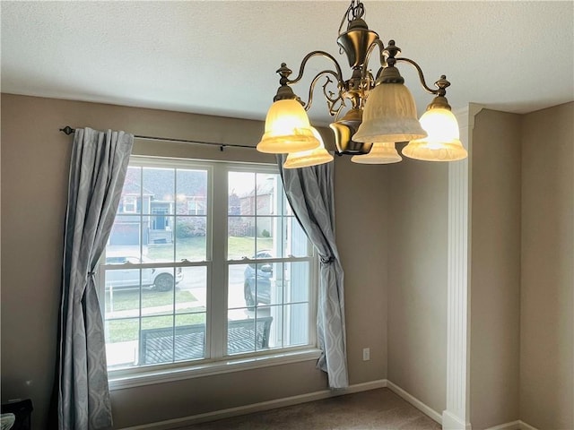 room details featuring a textured ceiling, baseboards, and an inviting chandelier