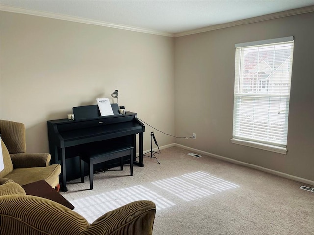 sitting room with crown molding, plenty of natural light, visible vents, and baseboards