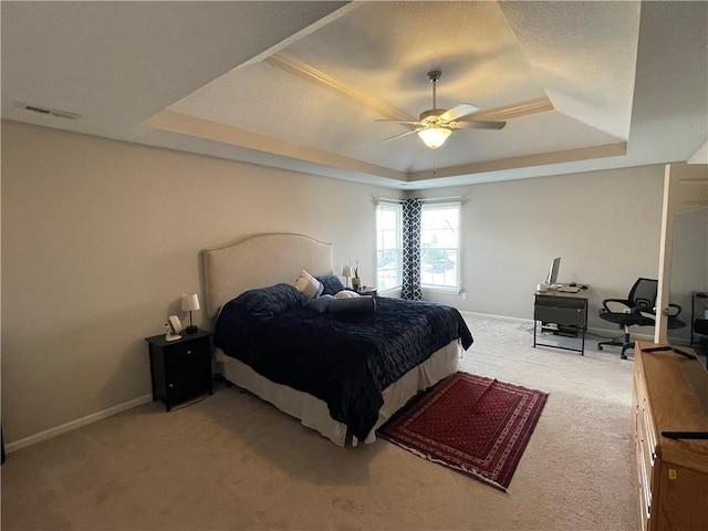 bedroom featuring carpet flooring, visible vents, baseboards, and a tray ceiling