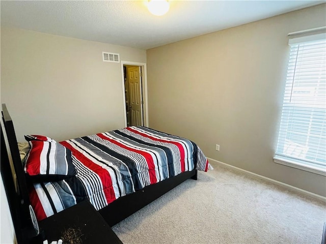 carpeted bedroom with visible vents and baseboards