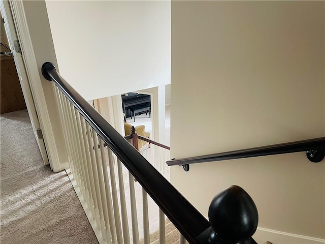 stairway featuring carpet flooring