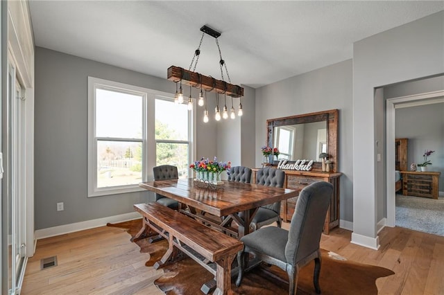 dining room with visible vents, light wood-type flooring, and baseboards