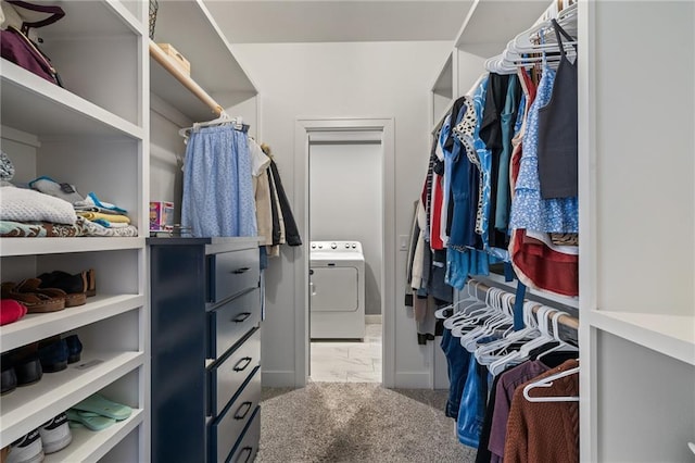 walk in closet with washer / dryer and light colored carpet