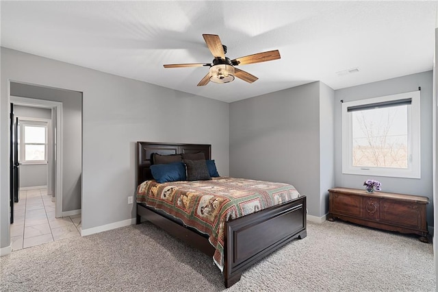 bedroom featuring visible vents, light carpet, baseboards, and ceiling fan