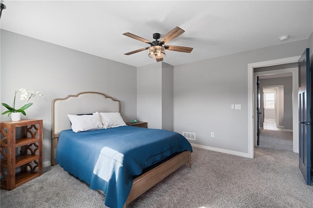 carpeted bedroom featuring visible vents, baseboards, and a ceiling fan