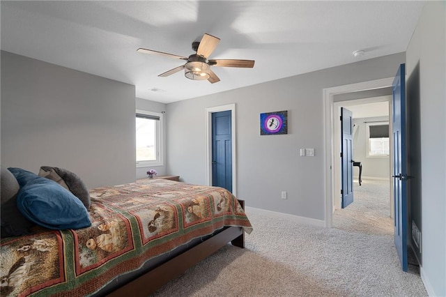 carpeted bedroom featuring visible vents, baseboards, and a ceiling fan