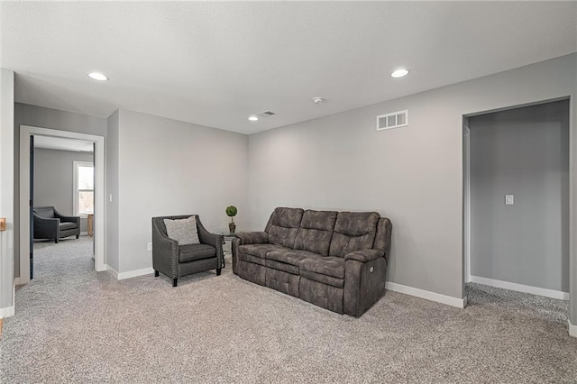 carpeted living area with visible vents, recessed lighting, a textured ceiling, and baseboards