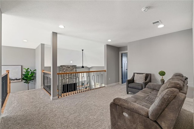 carpeted living area featuring visible vents, a textured ceiling, baseboards, and a ceiling fan