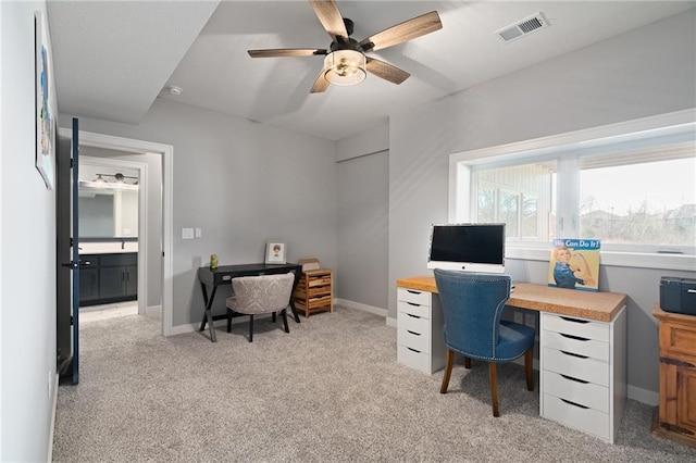 office with visible vents, light carpet, baseboards, and ceiling fan