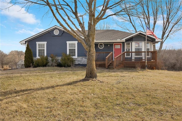 ranch-style home with covered porch, a shingled roof, and a front yard