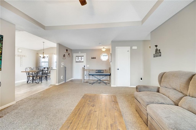 living room with a ceiling fan, carpet, and baseboards